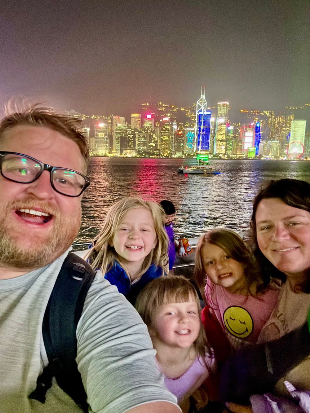 The family of five stands together on a busy street in the Yau Tsim Mong district of Hong Kong