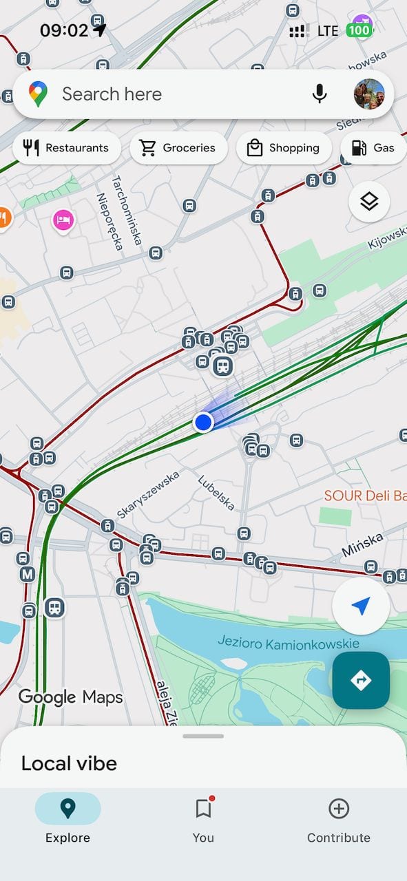 Google Maps open on a smartphone showing the Warsaw transit map with red tram lines, green train lines and a blue location dot