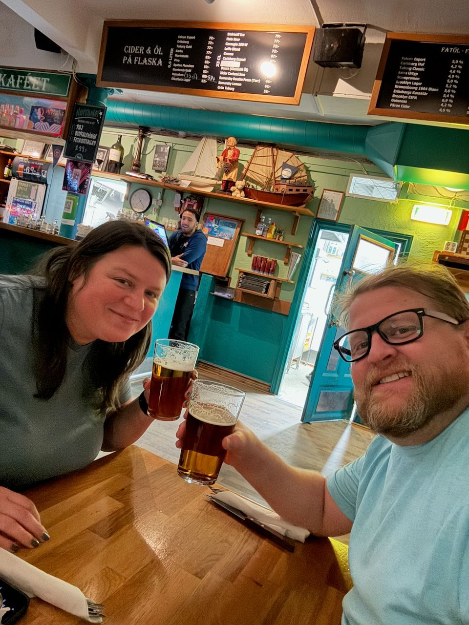 Adam and Lindsay taking a selfie with draught beers at a small bar in Malmö, Sweden
