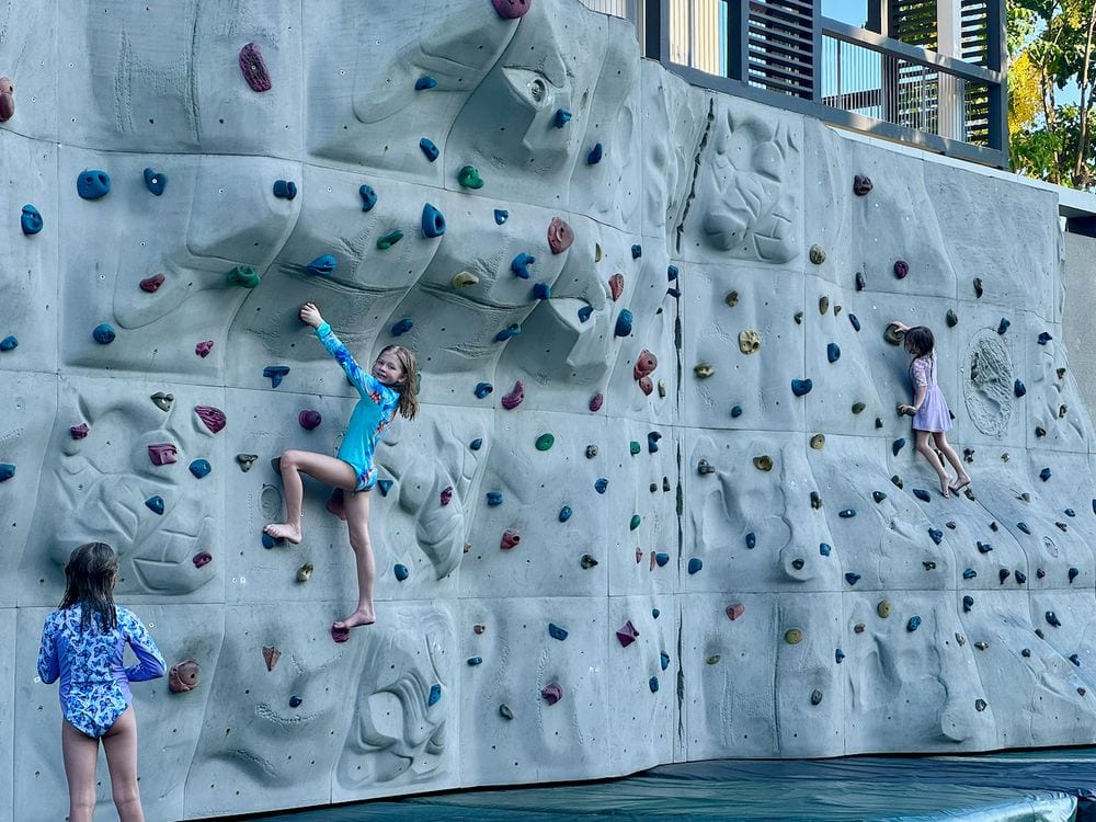 Three girls on a climbing wall at a Da Nang resort