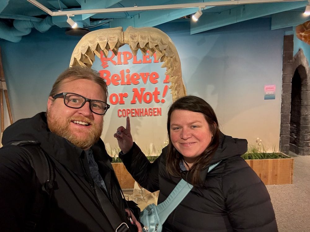 Adam and Lindsay taking a selfie standing inside a giant megalodon jaw exhibit at Ripleys Believe It or Not in Copenhagen
