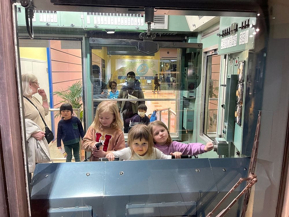 Children look through the window of a vintage subway car exhibit at the Tokyo Metro Museum.