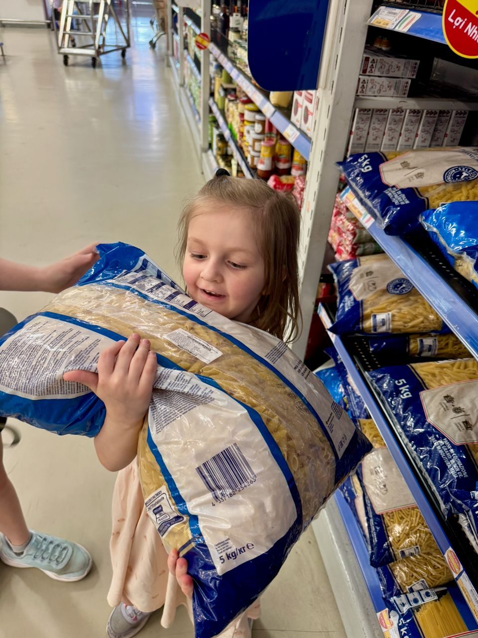 Harper holding a 5kg bag of pasta at a Vietnamese supermarket
