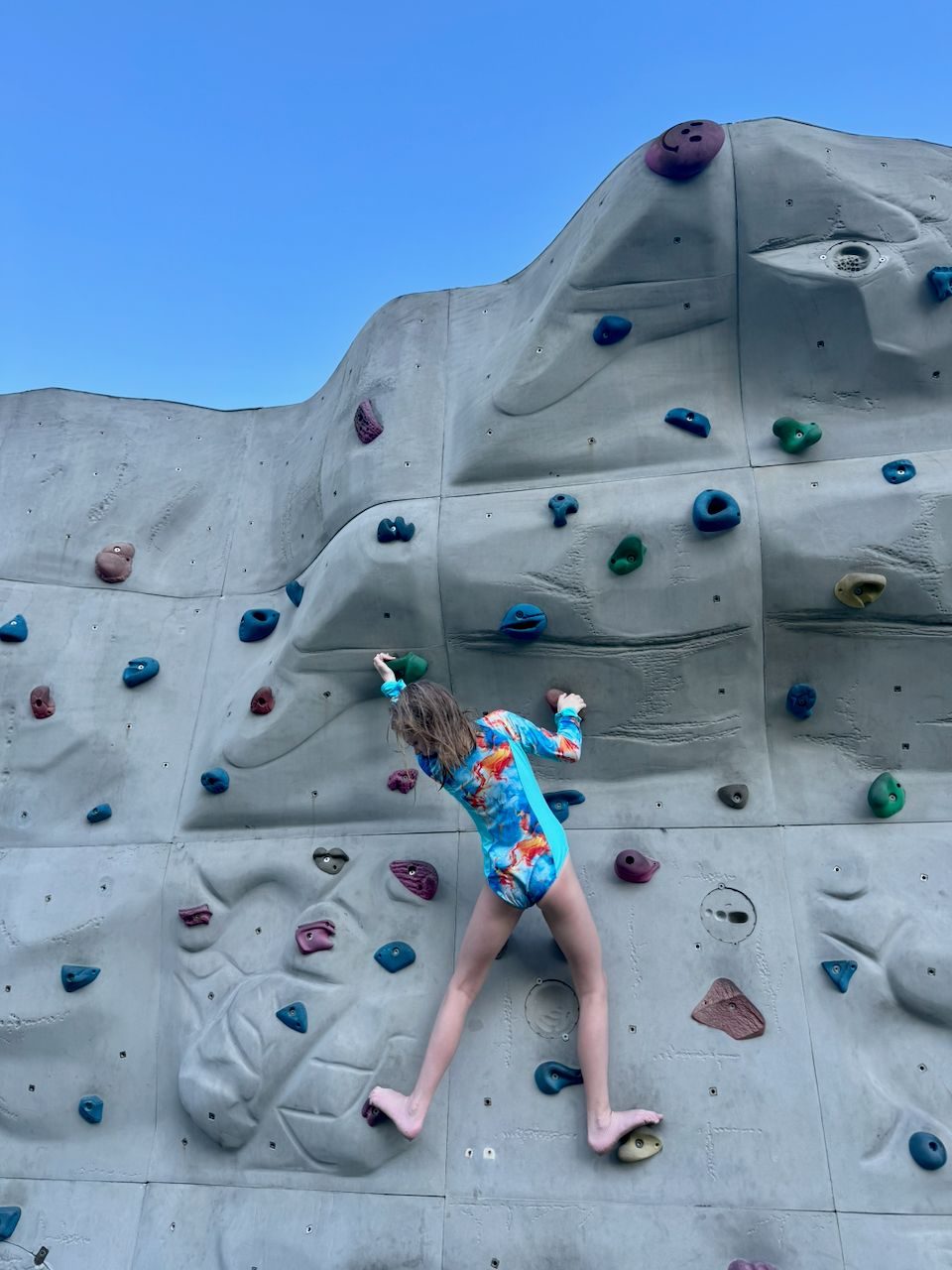 Lily barefoot on the climbing wall at Da Nang beach