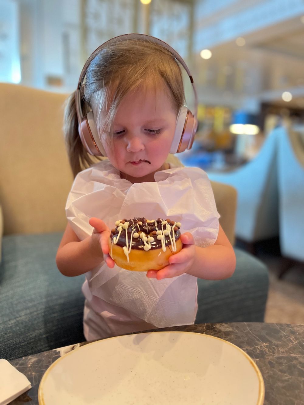 Harper holding a donut with both hands very seriously on the Queen Mary 2