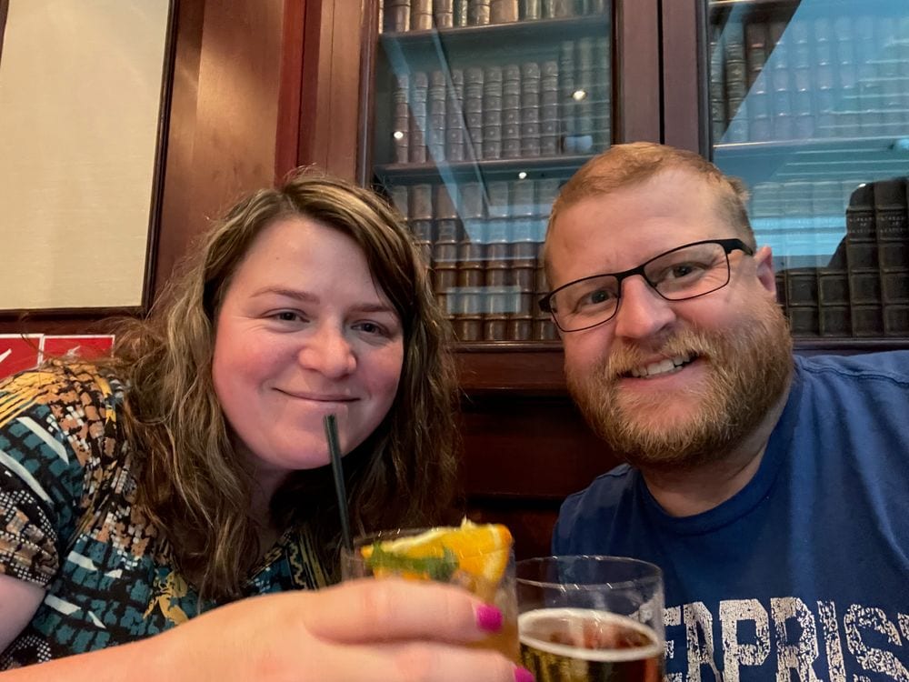 Adam and Lindsay toasting with drinks at a bar on the Queen Mary 2