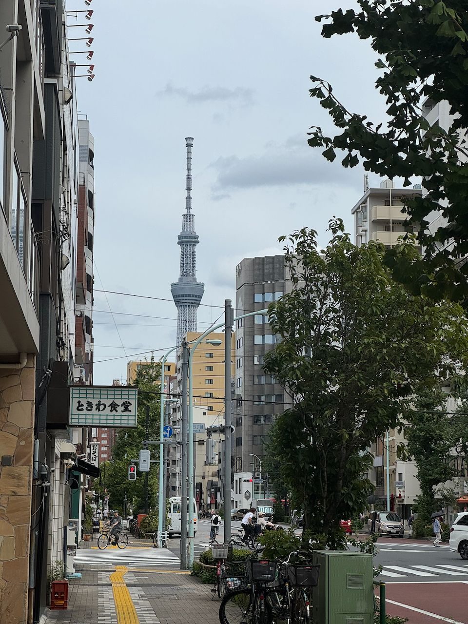 Tokyo Skytree framed at the end of a quiet Iriya street with a vintage diner sign in the foreground